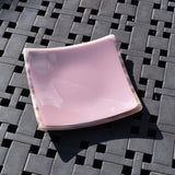 Violet/light purple fused glass dish that is 6&quot; square with multi-color rim and back on a steel grid.