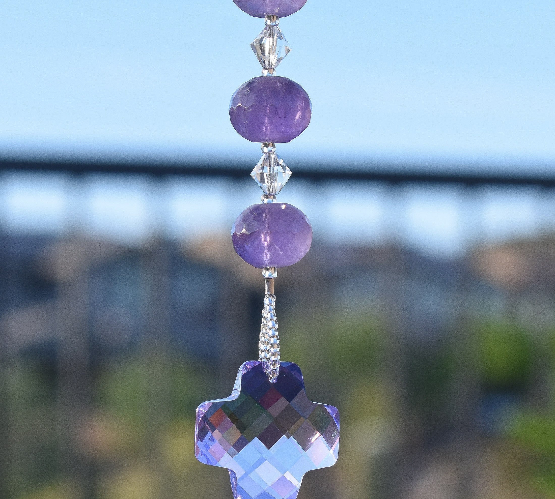 Amethyst beads paired with small clear crystal beads and anchored by a large, faceted, purple crystal pendant, hanging vertically.