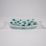 Pure white square glass dish with round glass pebblest; in various shades of teal green. Tray is 6 inch square with sloped corners.