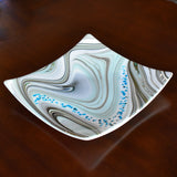 Large 12&quot; glass tray on wood table. Tray is white with swirl pattern in gray, tan and aqua, embellished with flecks of cream and aqua glass. Display as art or use as centerpiece or serving tray.