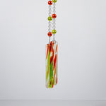 lime green and orange pearl beads hanging vertically on wire with smaller clear glass beads, against white background, anchored by two pieces of orange and green fused glass.