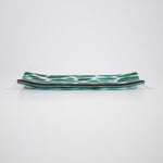 Channel-shaped rectangular serving tray made of clear glass with sparkling green design.