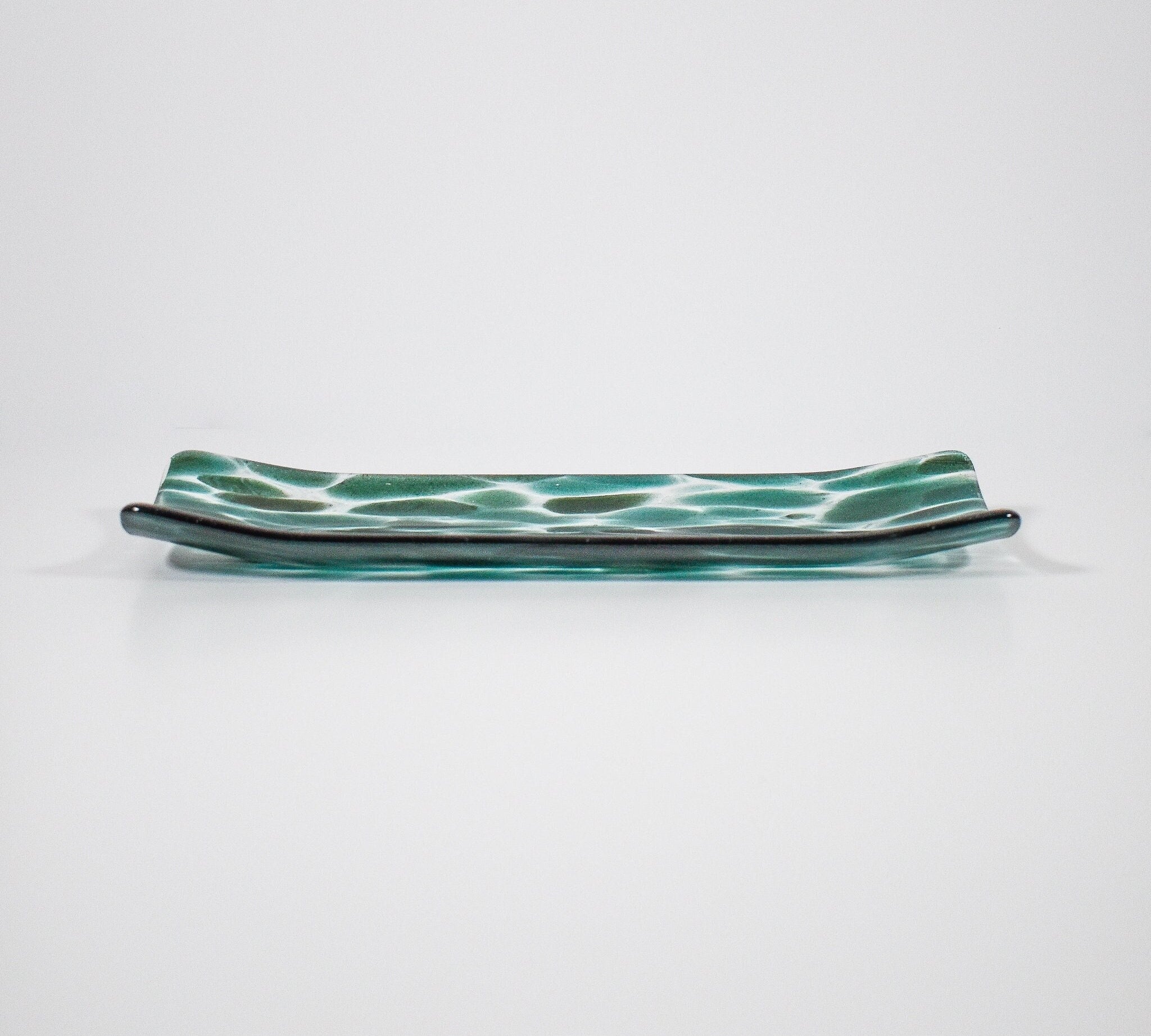 Channel-shaped rectangular serving tray made of clear glass with sparkling green design.