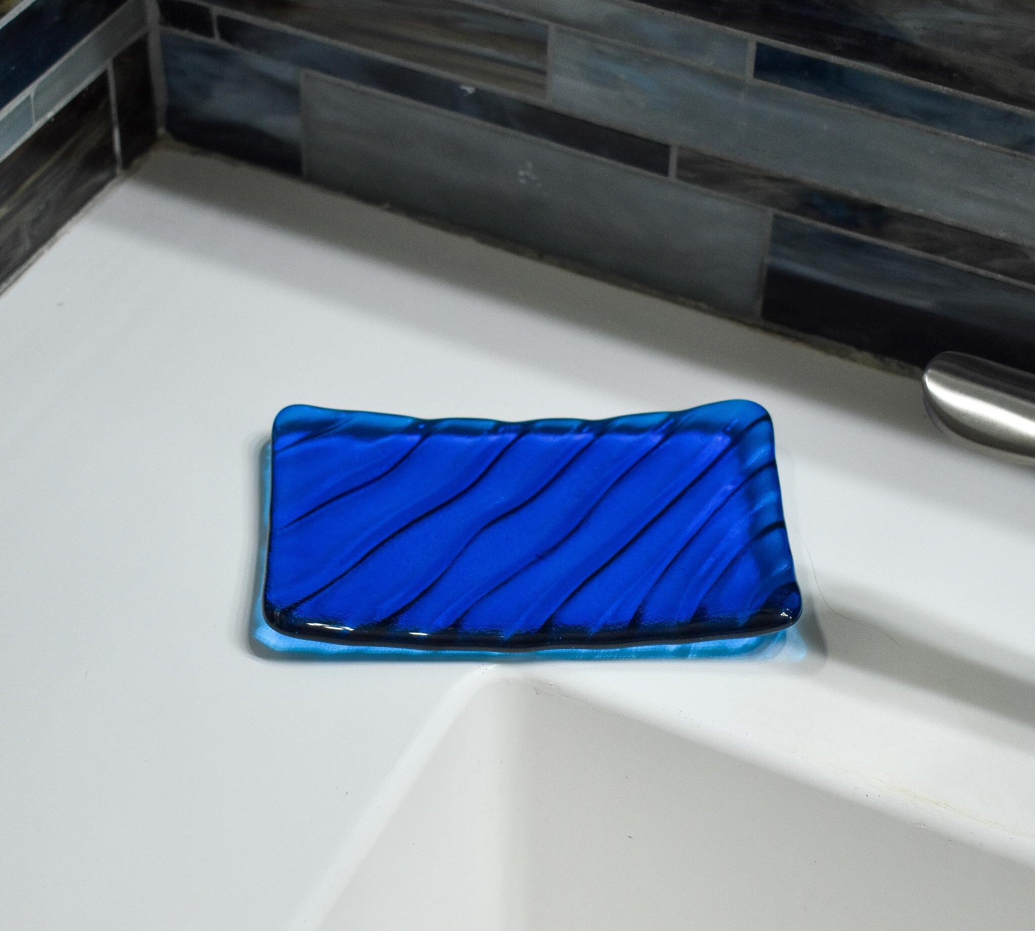 Aqua blue soap dish, rectangular, with wave design.