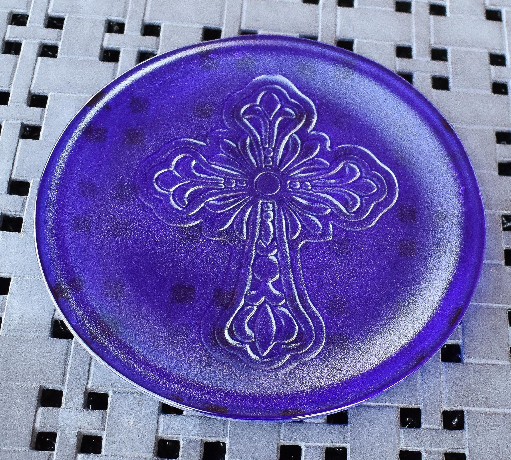 Round glass platter made with dark, transparent iridescent blue glass, embossed with elaborate cross