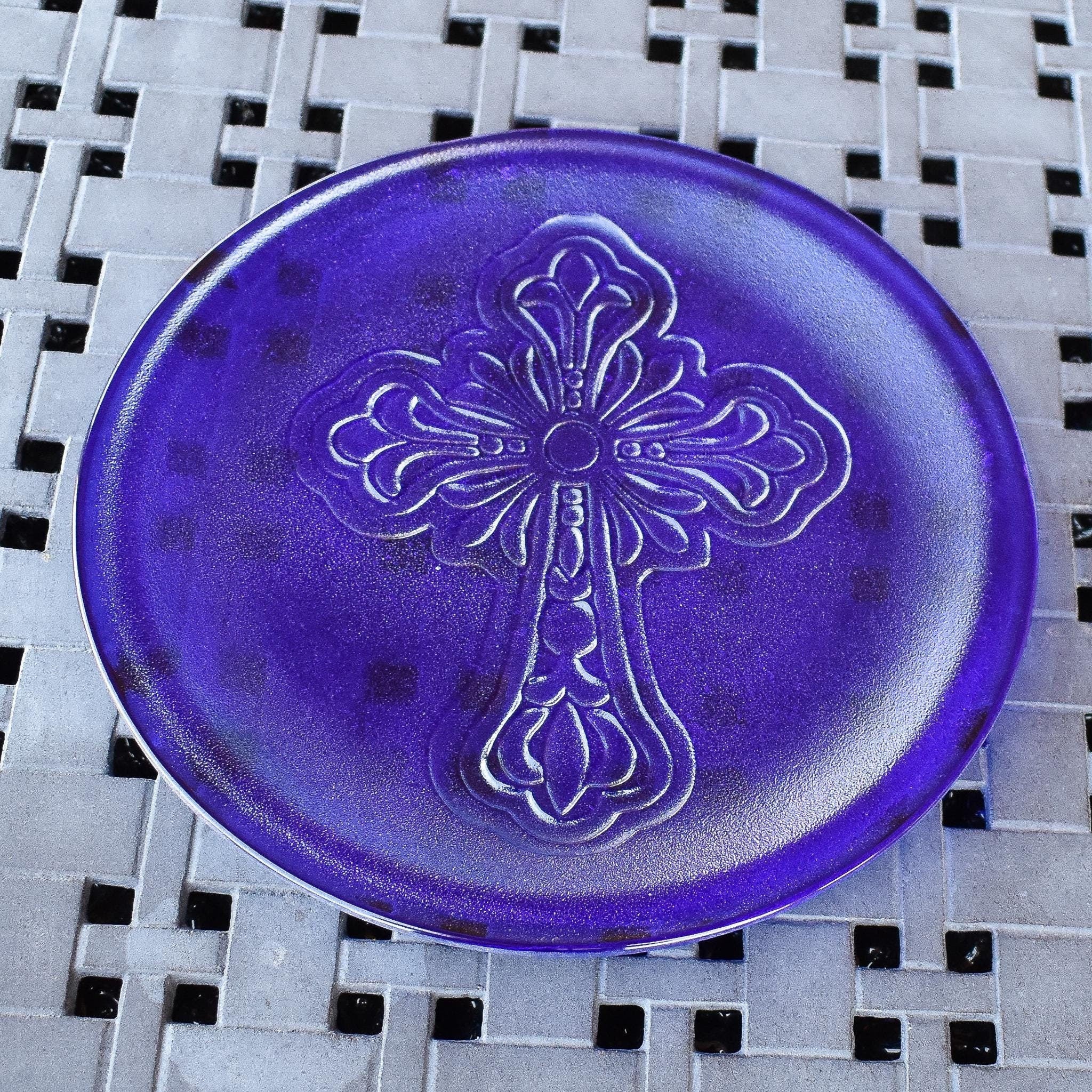 Round glass platter made with dark, transparent iridescent blue glass, embossed with elaborate cross.