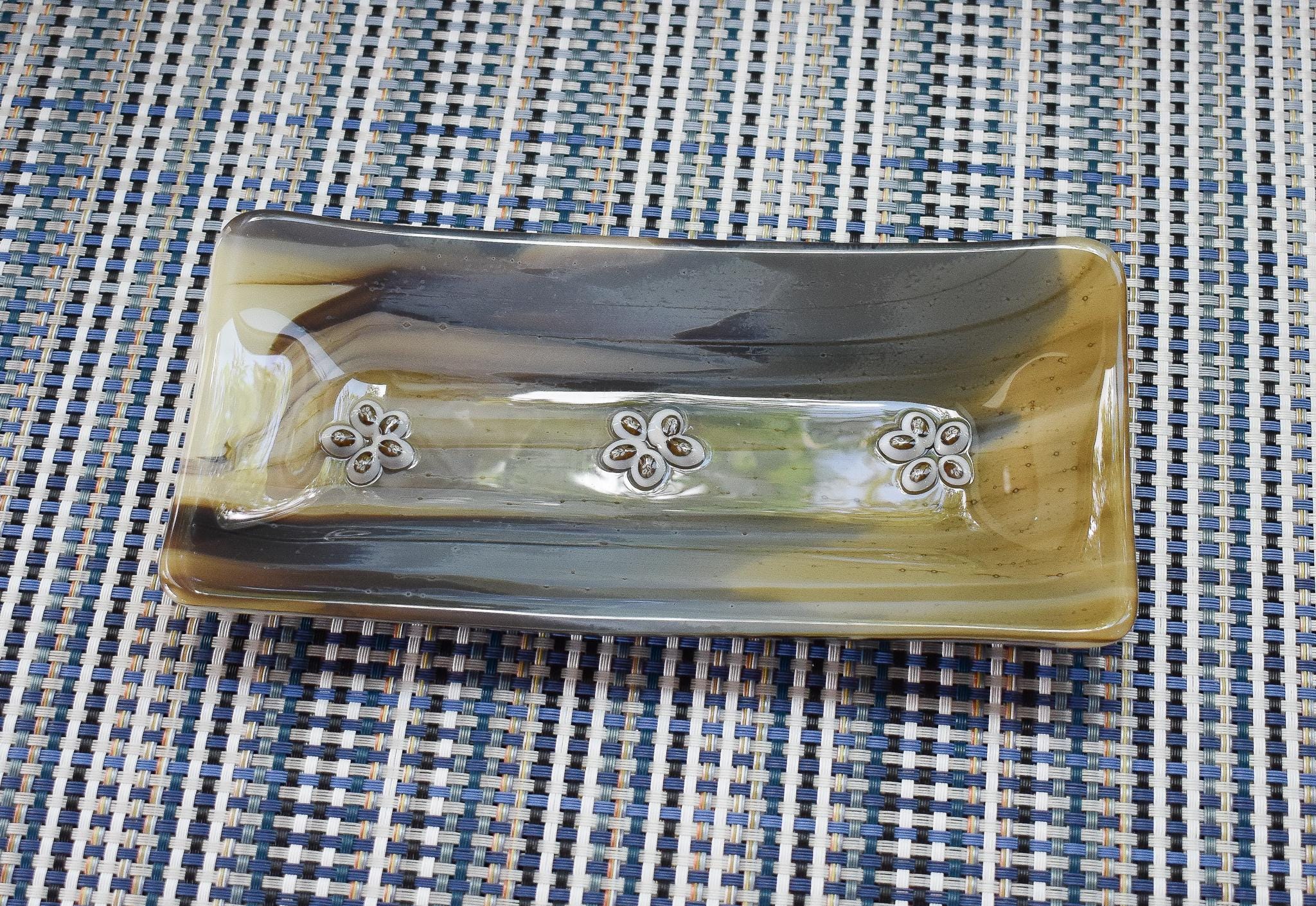Rectangular dish with a marbled effect in shades of brown, gray, and gold. The dish features three flower accents.