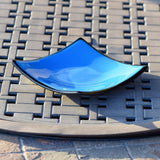 Square tray made with solid blue with black trim and black base. Corners are sloped.