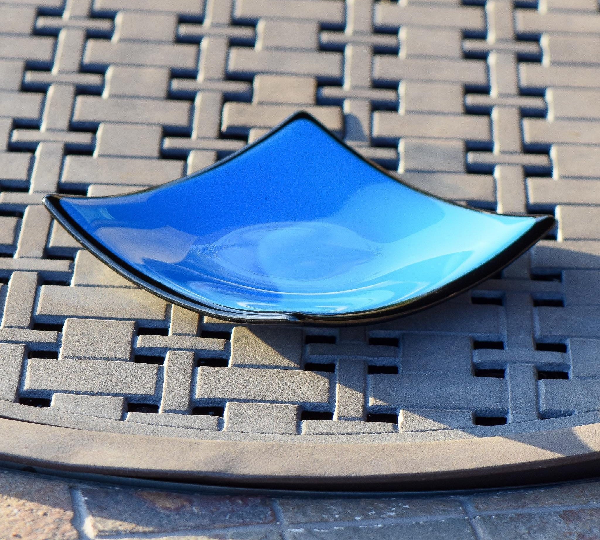 Square tray made with solid blue with black trim and black base. Corners are sloped.