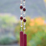 Large cranberry red jade stones beaded with glass and crystals, anchored by two pieces of pink fused glass, hanging vertically.