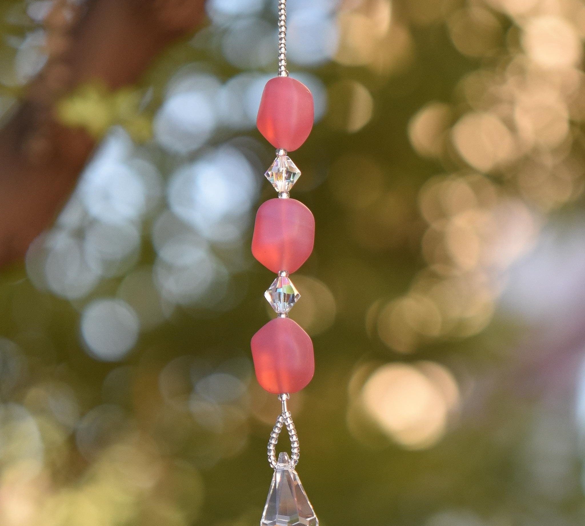 Small handcrafted glass sun catcher with pink beads, clear crystal beads and a crystal raindrop-shaped anchor.