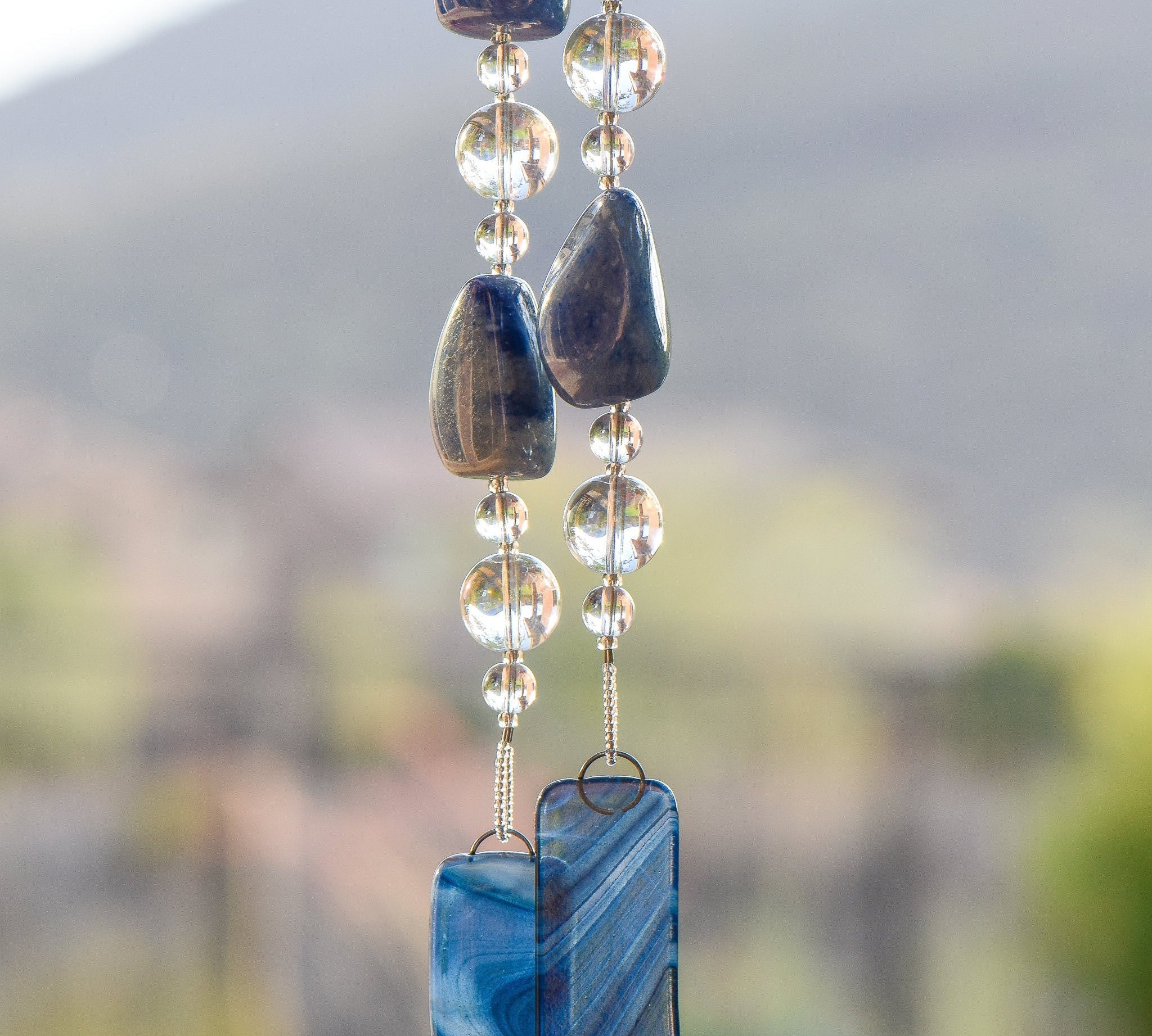 Very large blue lapis lazuli stone beads strung with clear glass beads and anchored by two pieces of blue swirl glass.