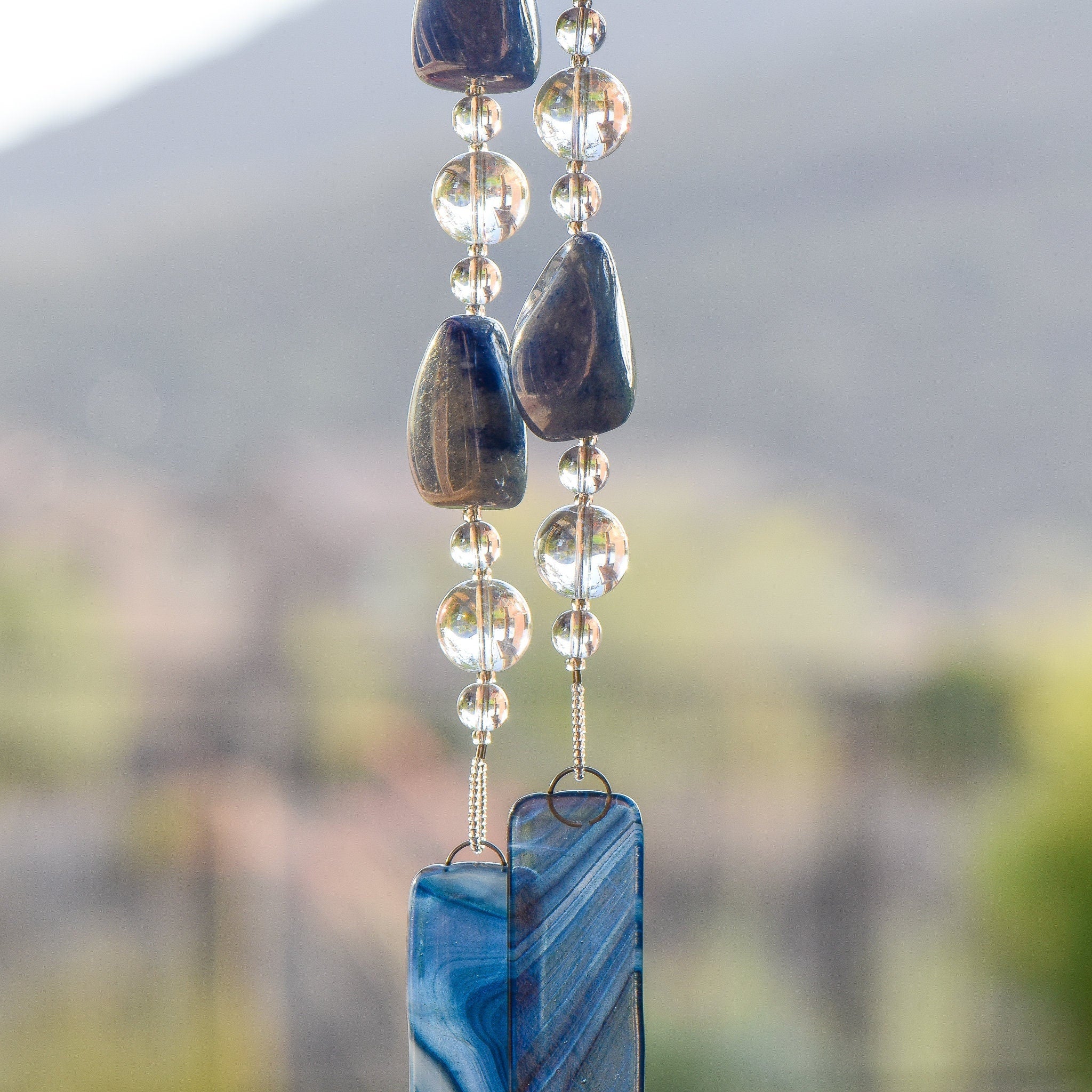 Very large blue lapis lazuli stone beads strung with clear glass beads and anchored by two pieces of blue swirl glass.