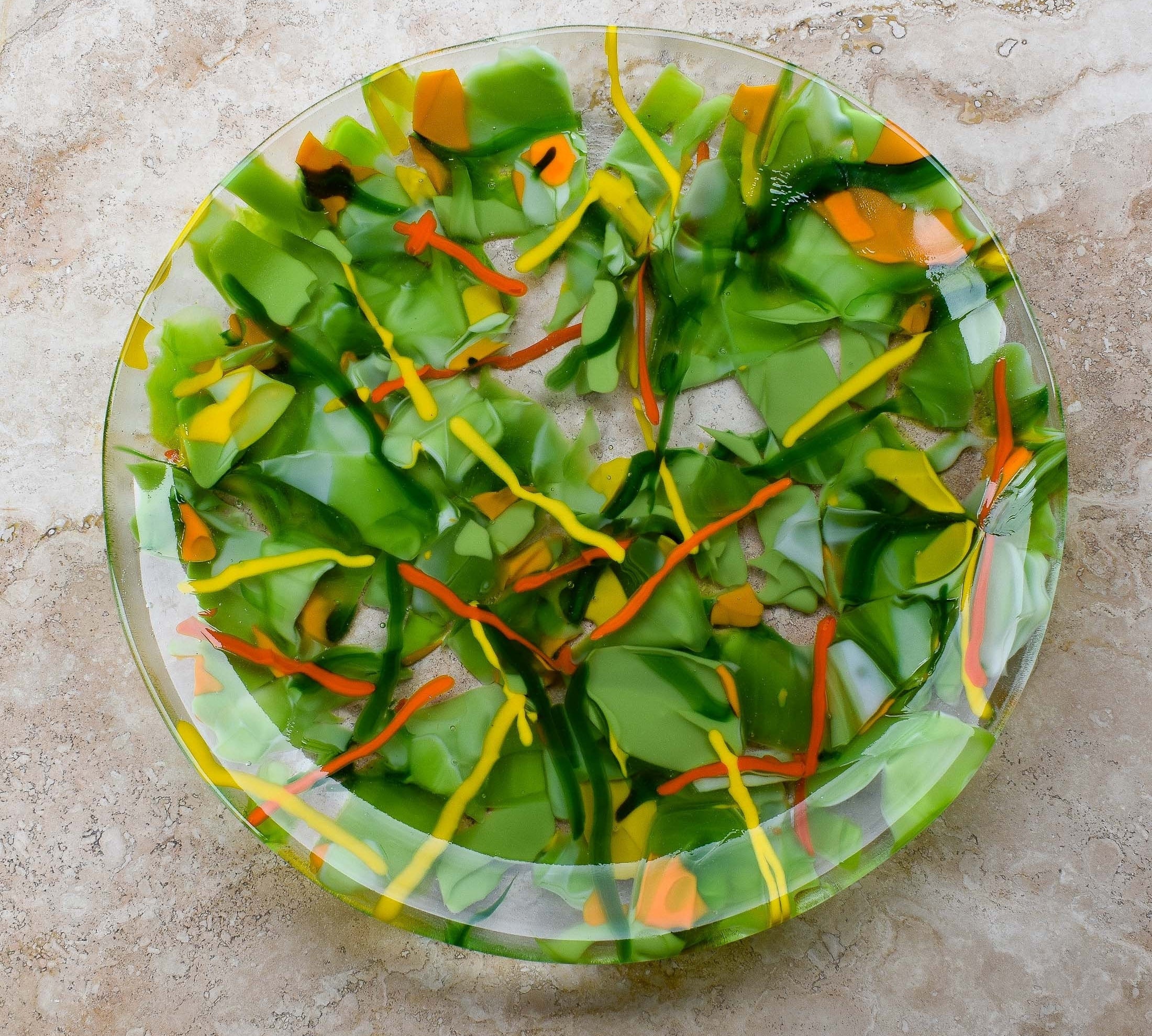 Large, round, glass platter made of green, orange and yellow glass