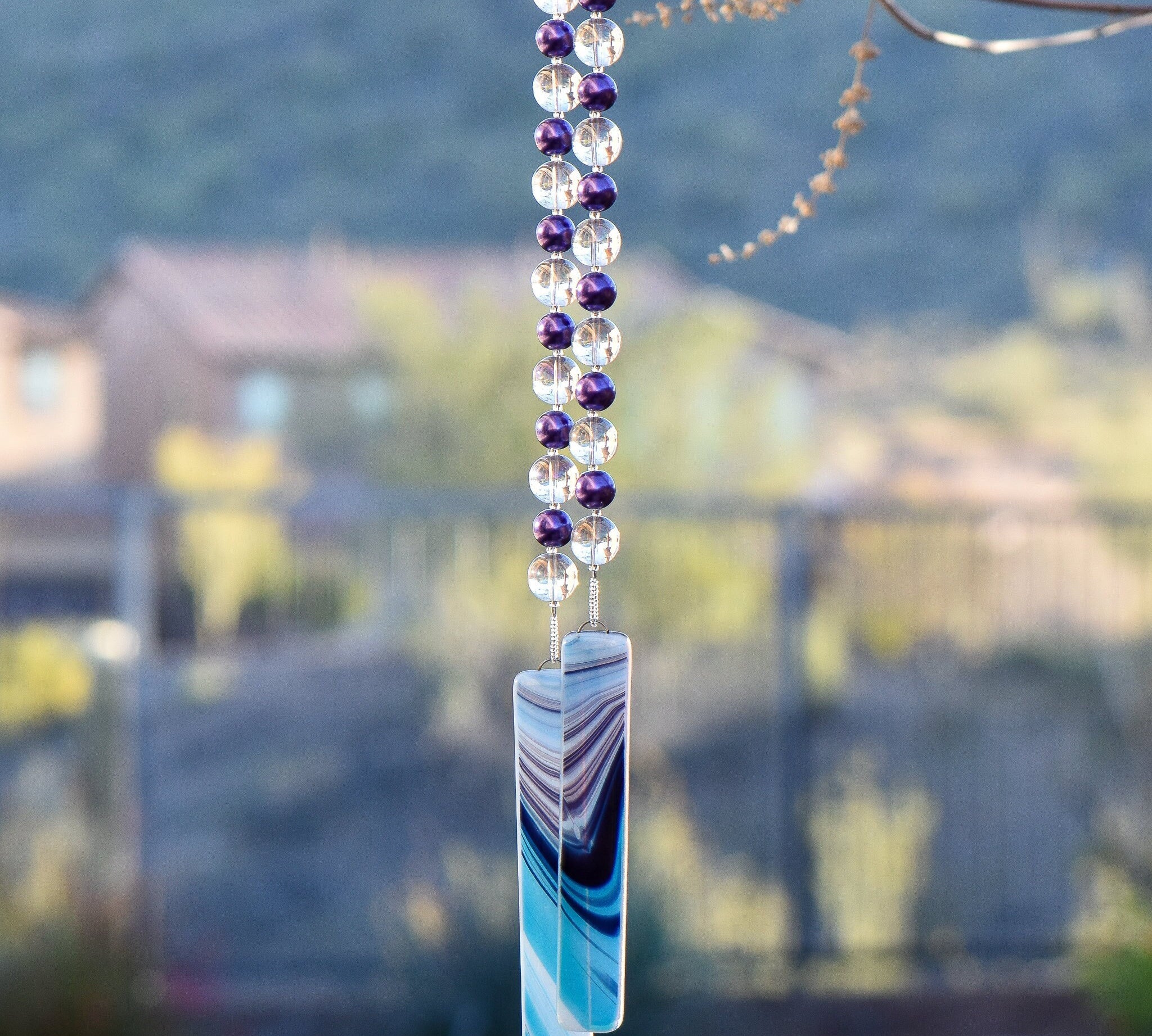 Purple glass pearl beads paired with large clear glass beads hanging vertically, anchored by two pieces of kiln-formed glass in aqua, purple and white