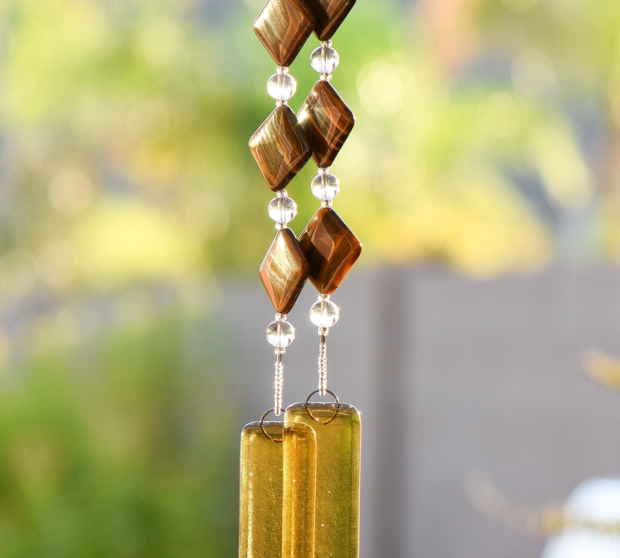 Diamond-shaped Zebra Iron Jasper stones strung with clear glass beads, hanging vertically anchored by two pieces of transparent gold glass