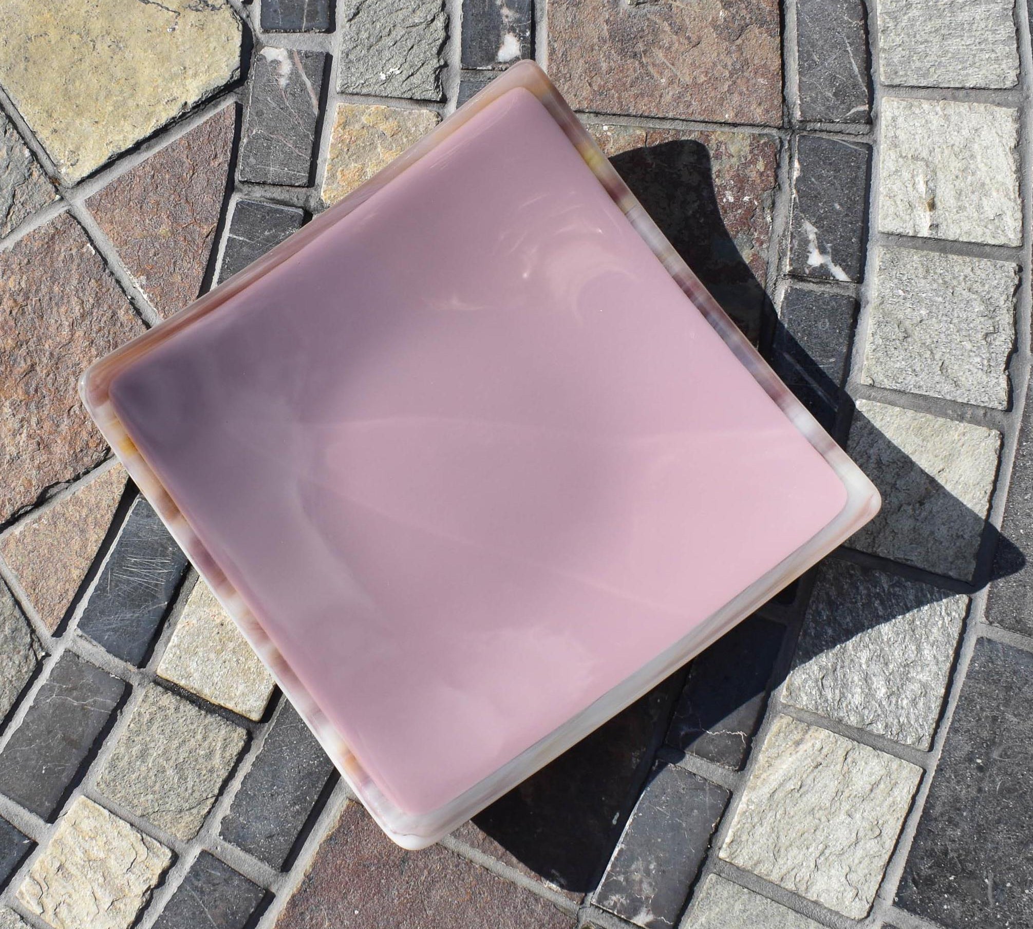 Lavender-colored square glass trinket tray on stone table