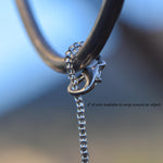 The top of a small sun catcher from Cinjo Handmade showing how the wire can be attached to a hook. A clasp is used to wrap the seed bead-covered wire around the hook and then clasp the wire to itself.