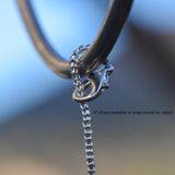 The top of a small sun catcher from Cinjo Handmade showing how the wire can be attached to a hook. A clasp is used to wrap the seed bead-covered wire around the hook and then clasp the wire to itself.