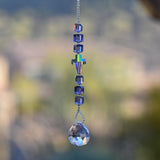 Small sun catcher with six purple crystal cube beads, a single crystal cross in paradise shine color, anchored by glass crystal prism