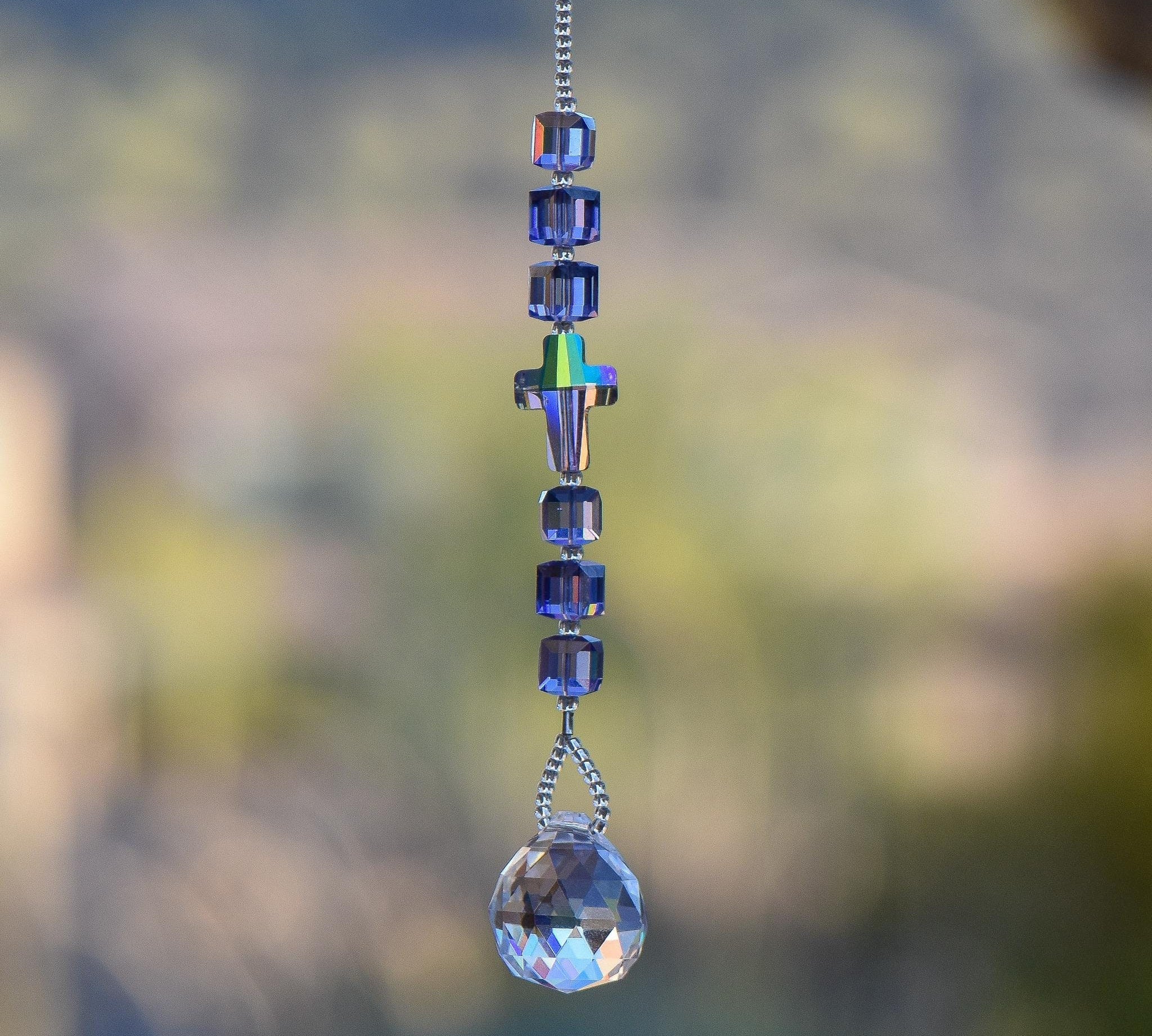 Small sun catcher with six purple crystal cube beads, a single crystal cross in paradise shine color, anchored by glass crystal prism