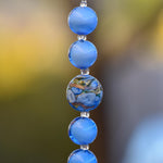 Puffed round murano glass bead in blue with gold and silver foil surrounded by pure blue murano glass beads in this small sun catcher.