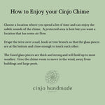 Instructions on how to enjoy a Cinjo Chime. Text on a light green background advises choosing a location with air flow, draping the wire over a nail, hook or tree branch and allowing room for movement. The fused glass pieces are thick and strong. The Cinjo handmade logo is at the bottom.