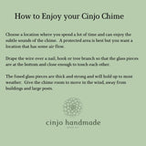 Instructions on how to enjoy a Cinjo Chime. Text on a light green background advises choosing a location with air flow, draping the wire over a nail, hook or tree branch and allowing room for movement. The fused glass pieces are thick and strong. The Cinjo handmade logo is at the bottom.