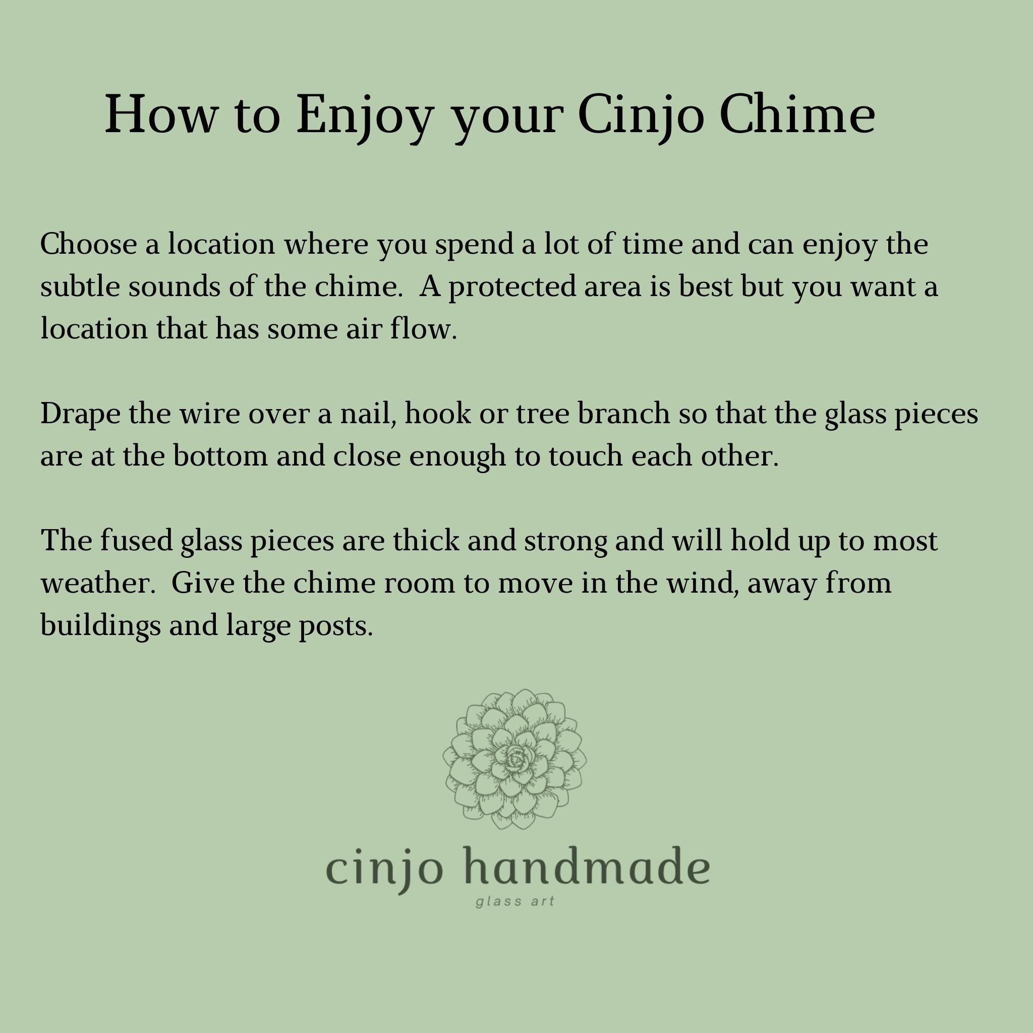 Instructions on how to enjoy a Cinjo Chime. Text on a light green background advises choosing a location with air flow, draping the wire over a nail, hook or tree branch and allowing room for movement. The fused glass pieces are thick and strong. The Cinjo handmade logo is at the bottom.