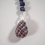Large sterling silver swirled pendant with purple rhinestones on white background.