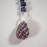 Large sterling silver swirled pendant with purple rhinestones on white background.