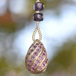 Sterling Silver pendant with small purple rhinestones anchoring seed bead-covered stainless steel wire, hanging vertically.