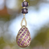 Sterling Silver pendant with small purple rhinestones anchoring seed bead-covered stainless steel wire, hanging vertically.