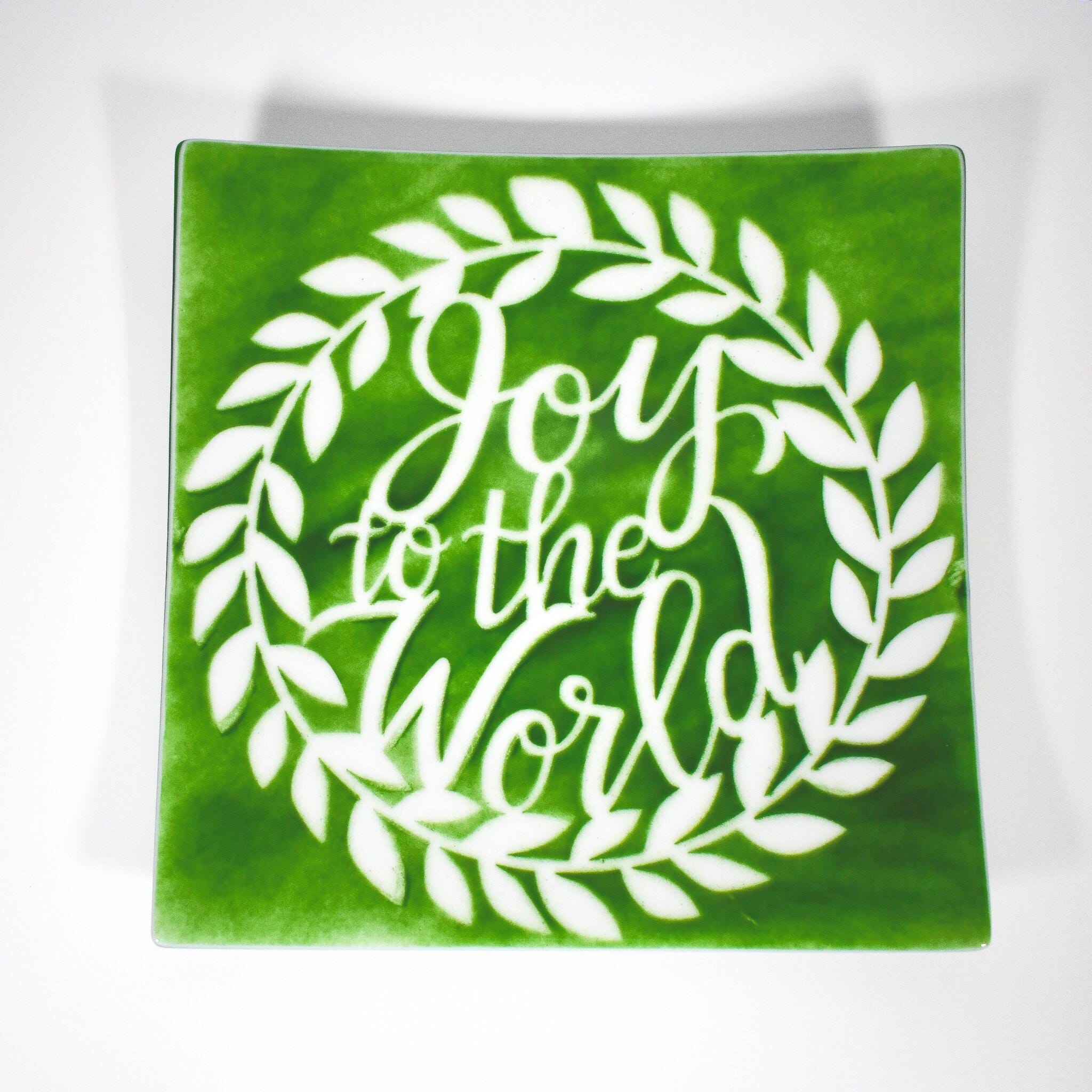 Large square fused glass platter with &quot;Joy to the World&quot; design in green with white, against white background.
