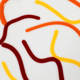 Detailed, closeup view of abstract design using orange, red and orange vitrigraph glass against vanilla cream.