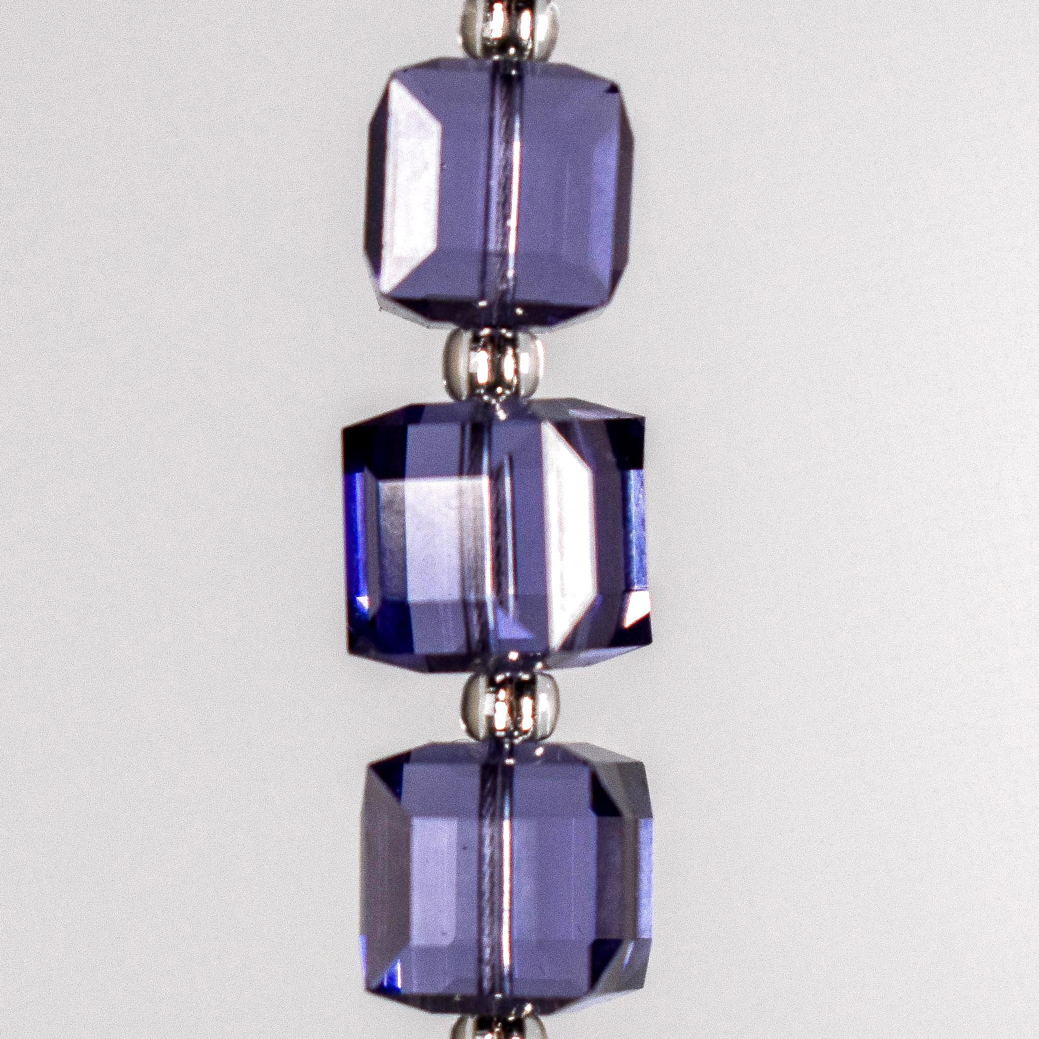 Three cube-shaped purple beads with silver-lined seed bead spacers in between. Hanging vertically against white background.