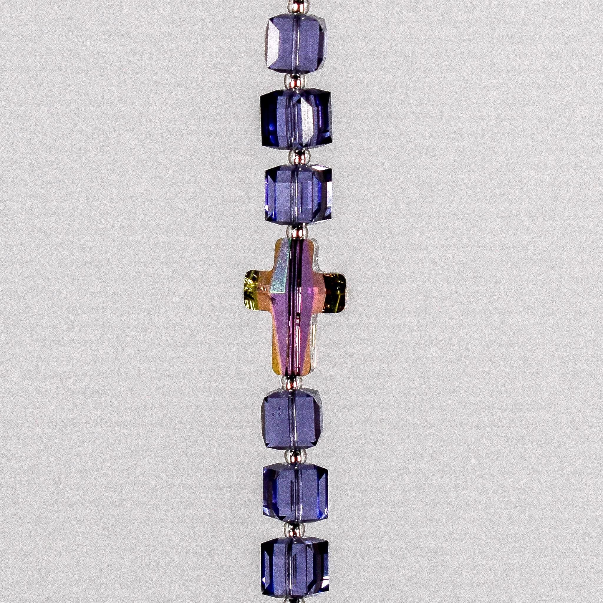 Small sun catcher with six purple crystal cube beads, a single crystal cross in paradise shine color, hanging vertically against white background.
