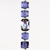 A strand of iridescent purple crystal beads with a clear crystal bead in the center. White background.