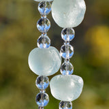 Close up view of 3 large Krobo tribe beads from Ghana showing the irregular but circular shape and the amazing aqua sea glass color. Between each of the large beads are three round faceted glass crystal beads.