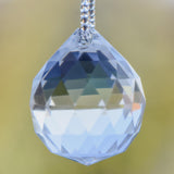Closeup view of a large, round, glass crystal faceted prism.