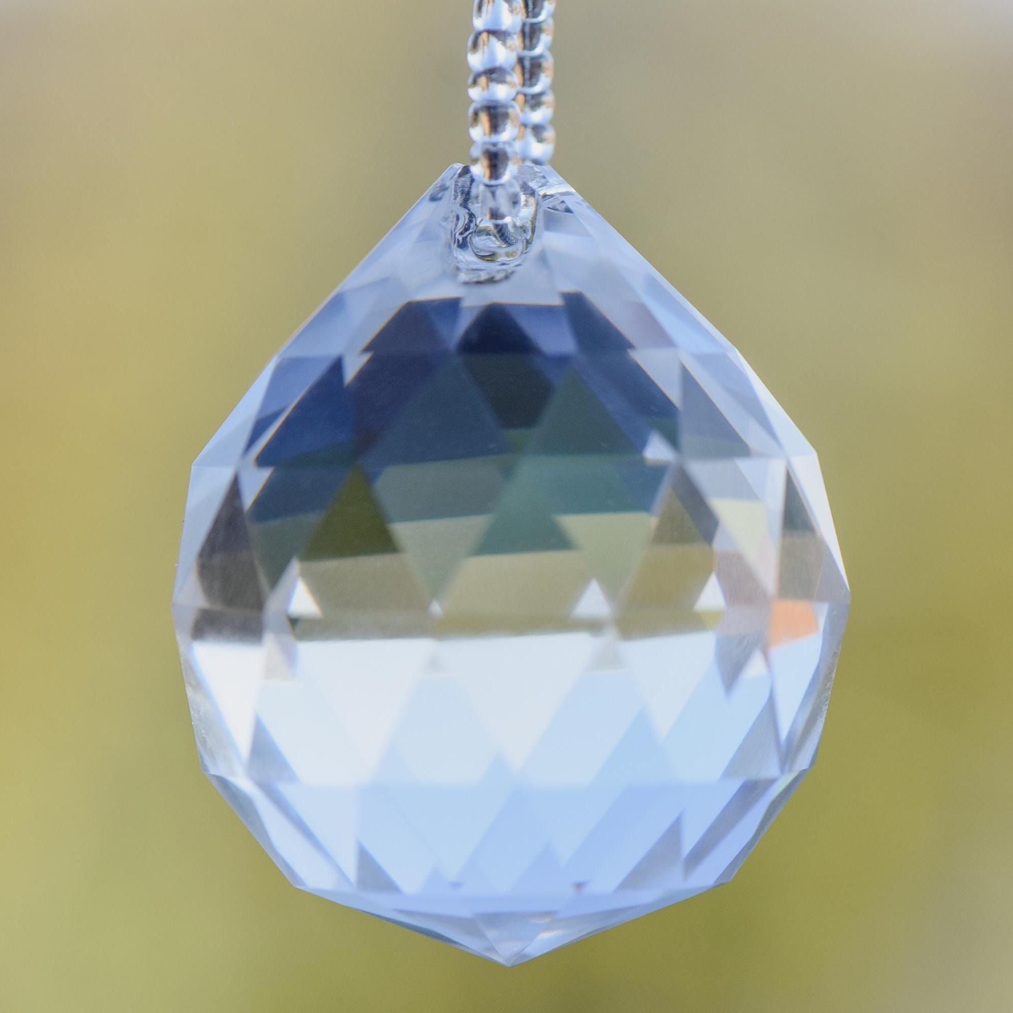 Closeup view of a large, round, glass crystal faceted prism.