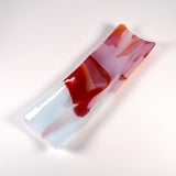 Angled studio photo of the channel tray on a white background, showing raised sides and red/orange swirls over icy white.