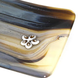A decorative glass dish with a flower-shaped accent. The dish features a flowing pattern of brown, beige, and gray hues. The flower accent is white with brown details.