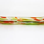 A long, rectangular glass dish with a curved shape. The dish is clear with green and orange color accents. The green is in the form of streaks and the orange is in the form of small, irregular shapes. The dish is likely used for serving or display purposes.
