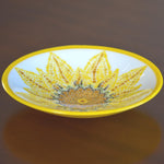 Round glass bowl with hand-painted sunflower design and bright yellow trim on wood table.
