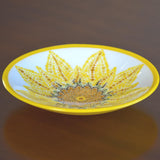 Round glass bowl with hand-painted sunflower design and bright yellow trim on wood table.