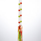 Two strings of glass beads hanging against white background, anchored by two pieces of green and orange fused glass.