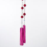 Large cranberry red jade stones beaded with glass and crystals, anchored by two pieces of dark cranberry pink fused glass, hanging vertically against white background.