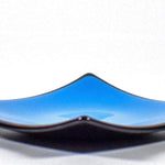 Square fused glass dish with solid blue center, black trim and black base, sitting white surface.