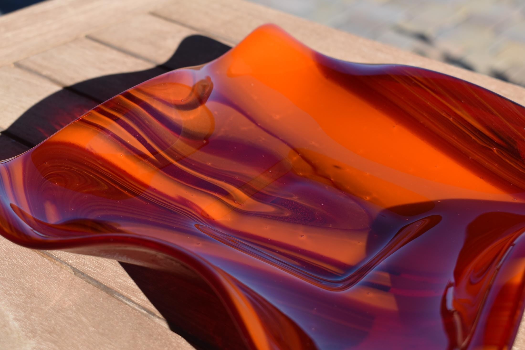 Close up view of the glass used to make the wave edge bowl. Swirls are made of opaque orange and transparent cherry red glass.